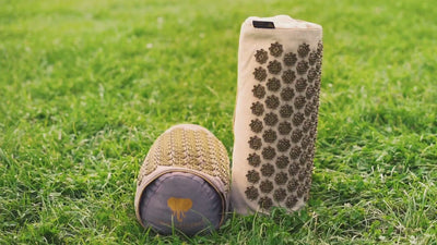 Akupressurkissen 2in1 - grün und Lagerungsrolle auf einer Wiese von CALM ELEPHANT